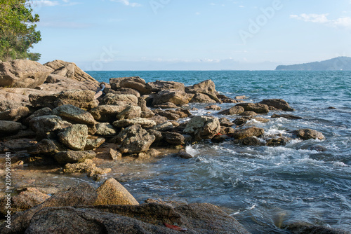 Rocky headlands and rocks are struck by powerful waves that crash with energy. Angra dos Reis – Rio de Janeiro, Brazil.
