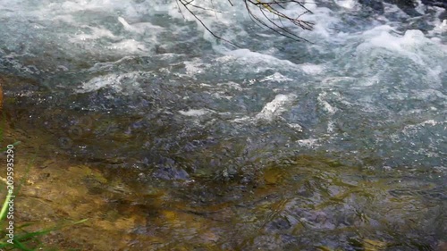 Real-time video recording with sound, showing a side and overhead view of a small river flowing with water, at 120 frames per second. B-roll footage for a film or television show