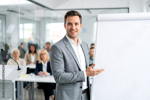 Professional businessman giving a presentation. Male speaker presenting at a corporate workshop.