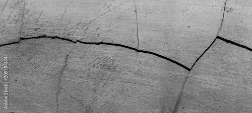 Cracks and deep scratches on the gray concrete surface.