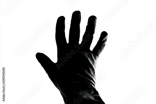 Hand silhouette reaching up against bright white backlight in high contrast monochrome for mental health marketing