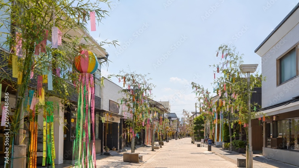 Fototapeta premium Tanabata festival showcasing sunny Japanese pedestrian street lined with bamboo and colorful Tanzaku Paper Cards decorations
