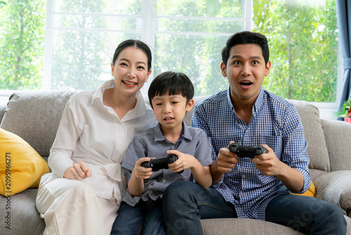 Cheerful young family with a little child laughing together in the living room, representing happiness, love, bonding, and sweet home concept.