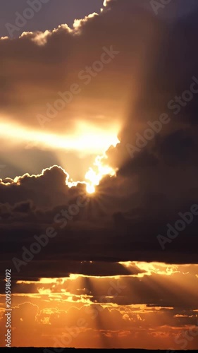 Sunlight breaking through heavy dark clouds at dusk.