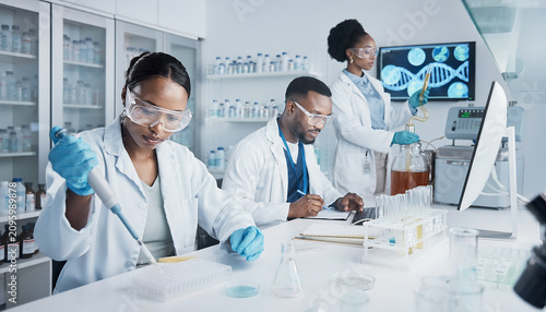 Female and male scientists conducting chemical experiments in a laboratory flask