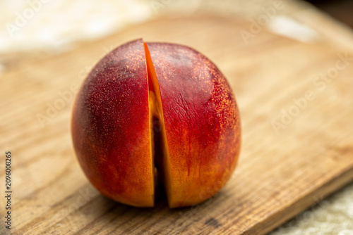 A ripe nectarine cut pictured on a wood board