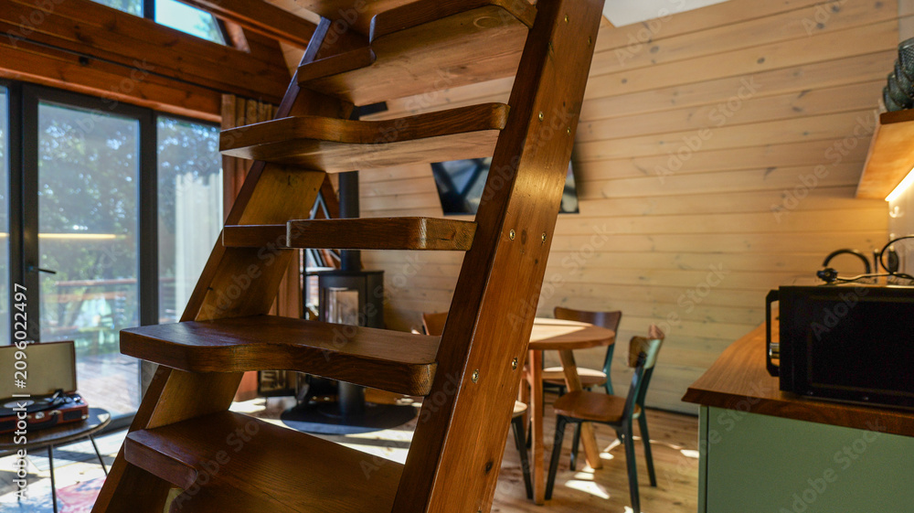 Obraz premium Cozy wooden cabin interior with a unique staircase and rustic charm
