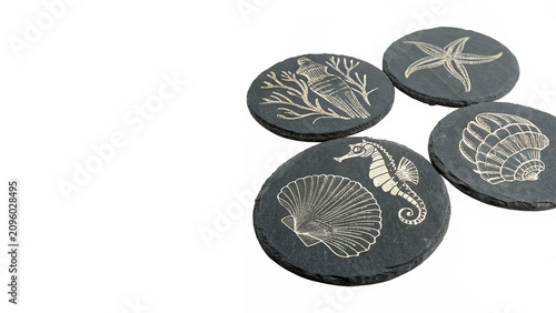 Photos Group of round black stone coasters with engraved marine ocean wildlife patterns