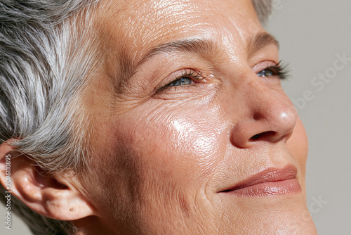 Elderly Arab woman macro portrait glowing skin closeup smiling serene expression natural silver hair radiant complexion