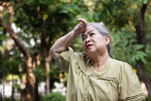 Foto Elderly asian senior woman tired, flushed and sweating from excessive summer hea