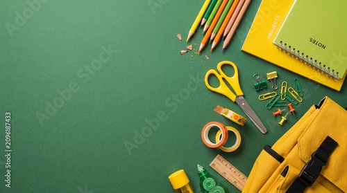 School supplies on green background notebooks pencils