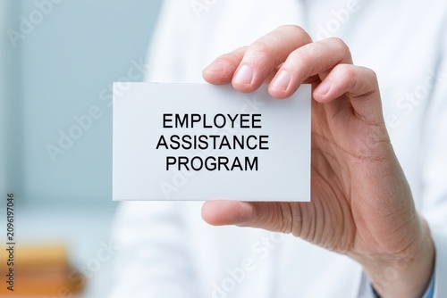 A hand holds an employee assistance program sign. It is a work help.
