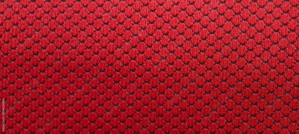 Фотография Close-up of textured red fabric with a repeating hexagonal diamond pattern, creating a three-dimensional surface effect