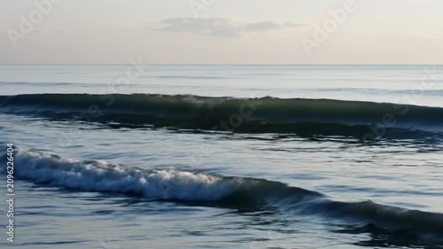 Waves rolling on a beach during the early morning hours at a calm seaside location