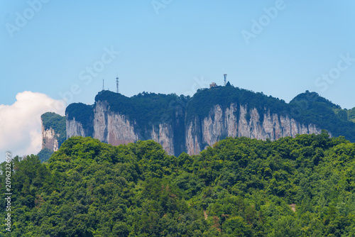 A view of the steep mountains and green forests located within the Three Gorges Reservoir Area in China under a clear blue sky