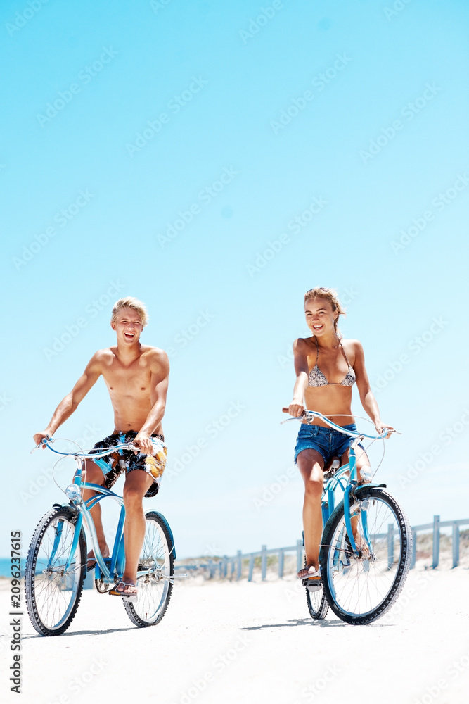 Fototapeta premium Cycling, happy and portrait with couple at beach for romantic date, summer vacation and bonding. Love, support and adventure with man and woman on bicycle outdoor for journey, freedom and space
