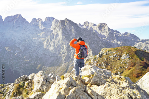 Картината върху платно Hiker shields eyes scanning jagged limestone ridges across Prokletije National Park
