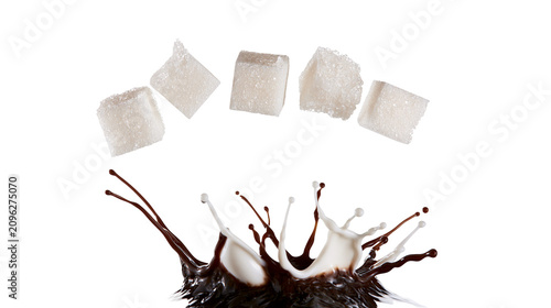 Bild auf Leinwand Five white sugar cubes suspended above a dynamic splash of dark chocolate and mi