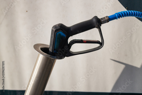 Pressure washer spray nozzle injector placed in socket at carwash station.