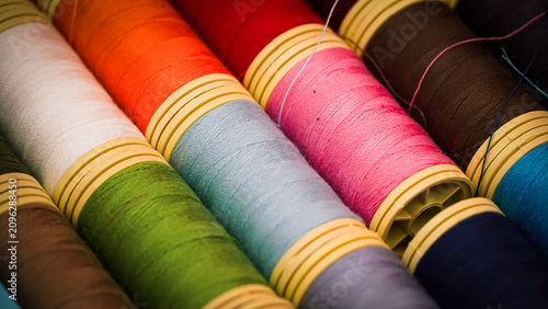 Colorful Sewing Thread Spools on a Vibrant Red Background