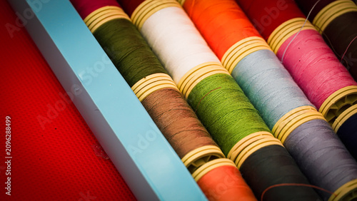 Colorful Sewing Thread Spools on a Vibrant Red Background