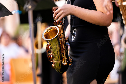 Musician performing jazz music on saxophone during an outdoor street concert