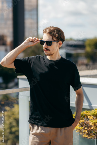 Man wearing black blank t-shirt with space for your logo or design. Mock up	

