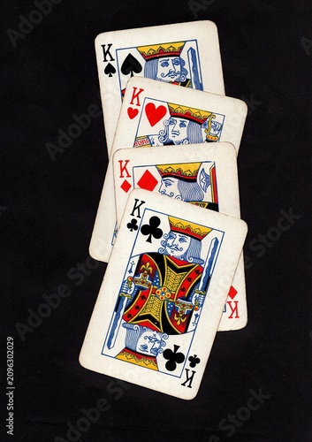 A hand of vintage playing cards isolated on a black background.
