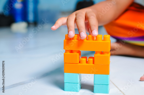 A young child plays with building blocks to learn.