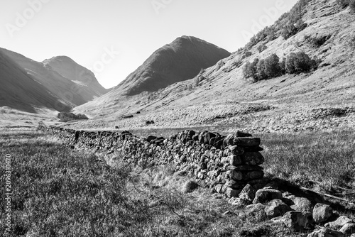 Foto Black and White view of a stone drywall leading your sight into Glen Coe, in the