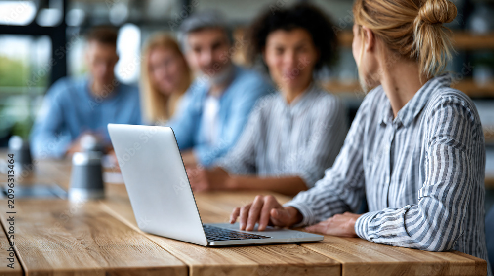 Fototapeta premium Faceless modern office collaborative meeting space with diverse professionals gathered around conference table, inclusive workspace concept, corporate photography, blurred office