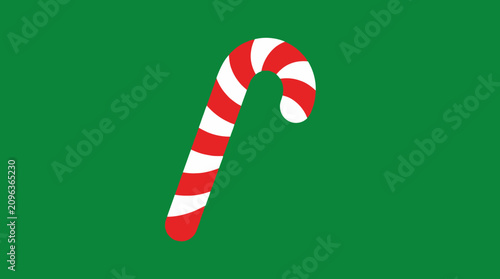 A red and white striped candy cane stands upright against a solid green background