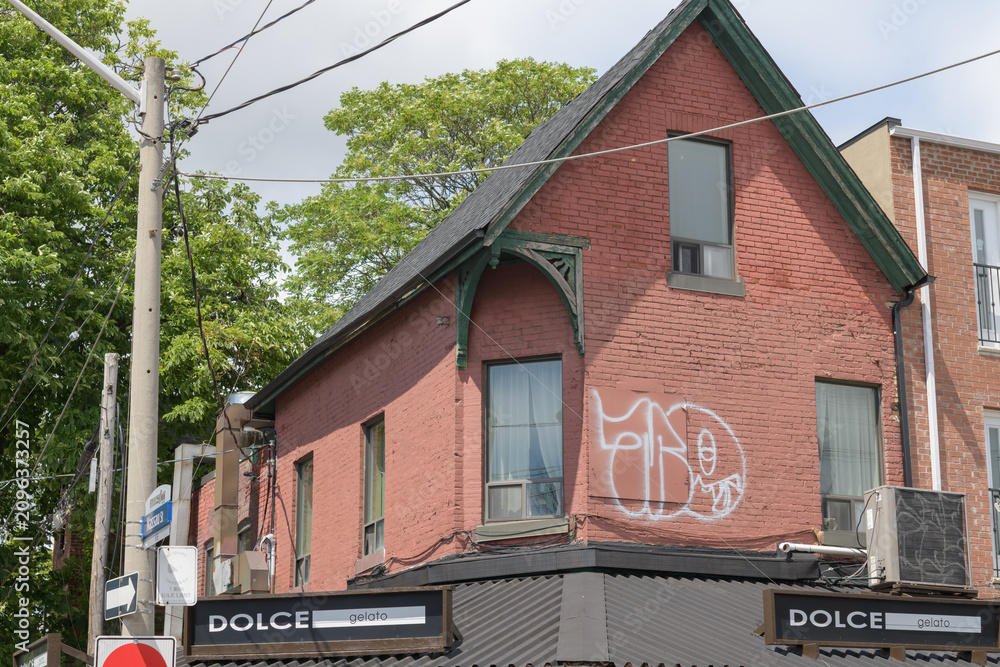 Obraz premium wide view of historic property and sign of Dolce Gelato, an ice cream shop, located at 234 Augusta Av, Kensington Market, Toronto
