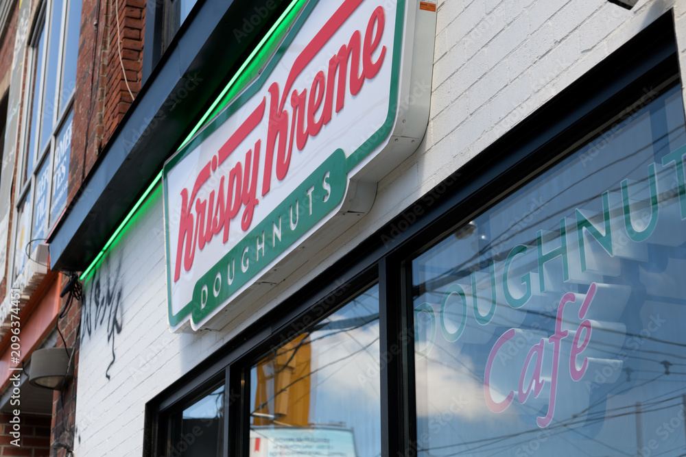 Obraz premium exterior building facade and signs of Krispy Kreme Café, a donut shop chain, located here at 830 College St, Toronto