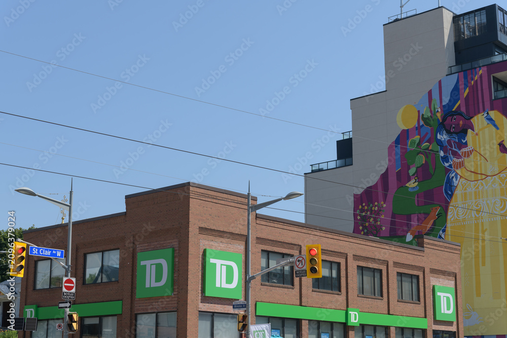 Obraz premium exterior building and corporate logo sign outside a TD bank branch located at 870 St Clair Av W; and huge mural art by Yasaman Mehrsa called 