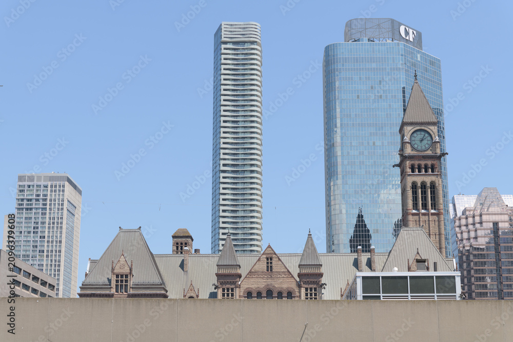 Obraz premium minimalist view of Old City Hall roofline, clock and bell tower, CF Cadillac Fairview headquarters office tower, and Massey Tower condominium, seen from Nathan Phillips Square, Toronto