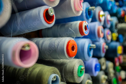 фотографія Rows of blue toned thread spools fill the entire frame, showing a dense pattern