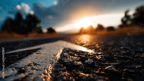 Close up of road arrow marking on asphalt surface during golden hour sunset