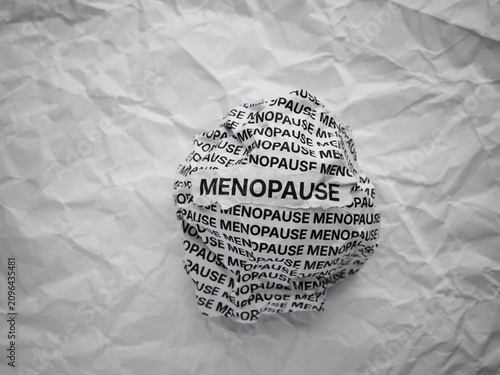 Quadro su tela Crumpled paper ball with words Menopause on a crumpled white paper background