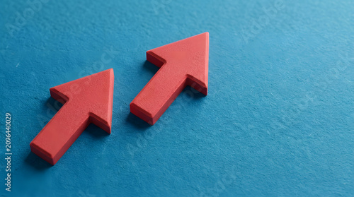 red arrows pointing up on blue background | business growth and financial progress concept | directional symbol for success and trends | minimalist professional stock photo