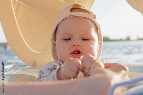 Close-up of a baby in a sun hat enjoying a day on the water