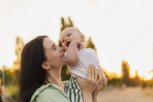 Joyful moments between mother and baby during sunset in a park