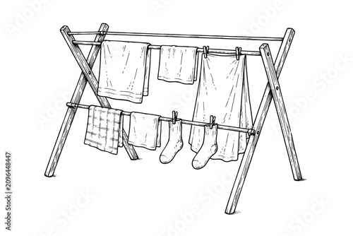Freshly washed clothes hang neatly on a folding drying rack, representing everyday household chores, clean laundry, and practical home living.