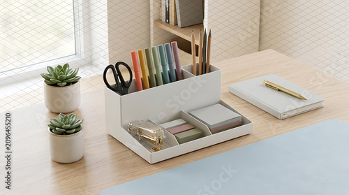 Organized desk supplies in a white storage tray on a wooden office table