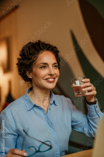 Canvas Print Professional woman smiling, drinking water, taking a break