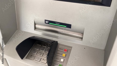 Close-up of a man's hand withdrawing a fifty euro banknote from an ATM cash machine