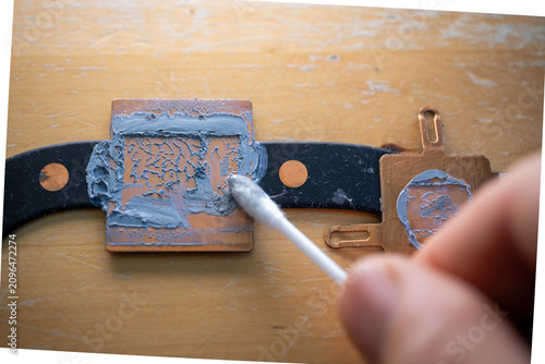 Technician applying thermal paste on computer processor copper heatsink. High angle macro view showing delicate hardware maintenance work concept detail for tech blog article banner or instruction man