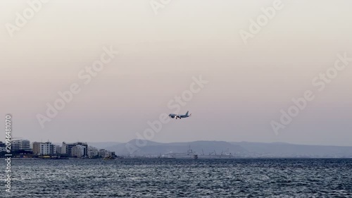 A plane is landing while flying low over the sea. Cyprus Island, tourist boats, Mediterranean Sea.