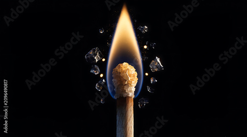 Ignited match macro with blue flame and sparkling fragments on black background for luxury advertising concept