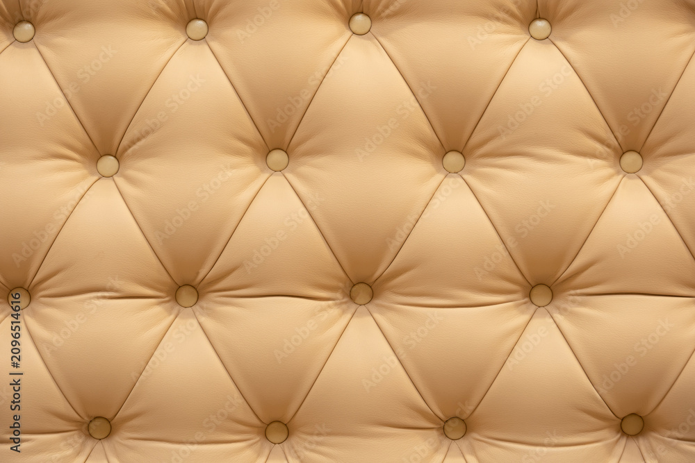 Obraz premium Beige tufted leather texture with buttons creating a luxury upholstery background pattern